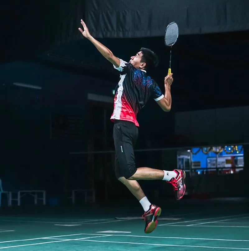 Badminton player jumping to hit the shuttlecock
