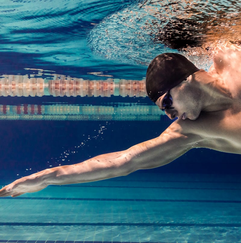 Male swimmer in the pool with swimming cap