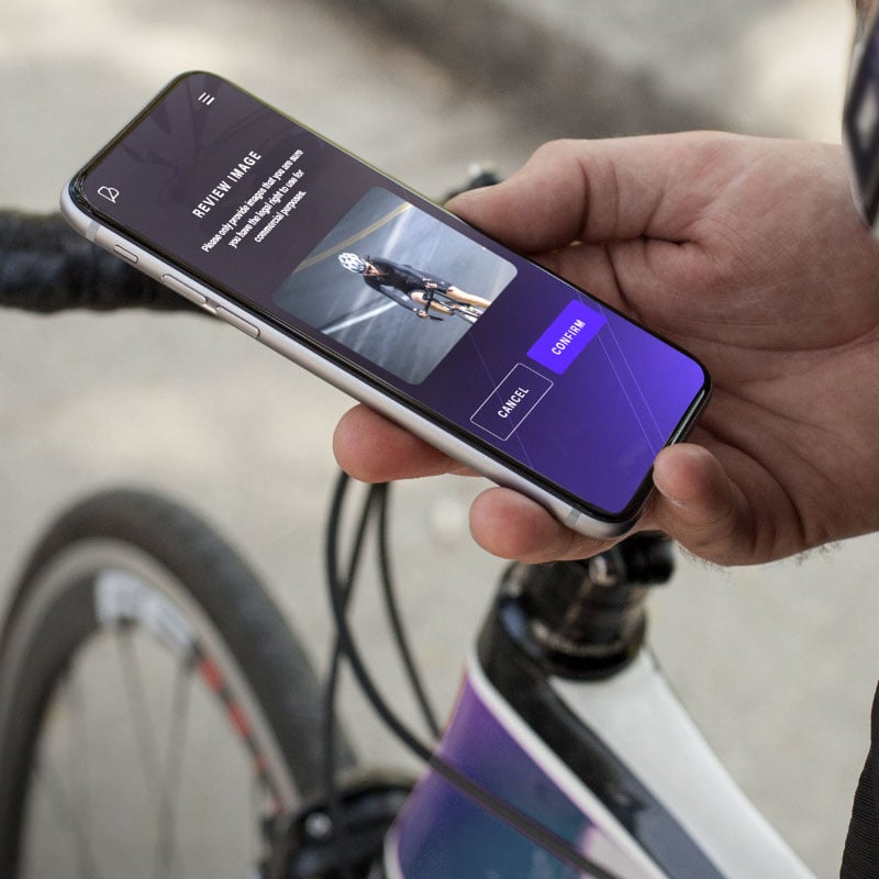 Cyclist updating their profile on their phone using Belong
