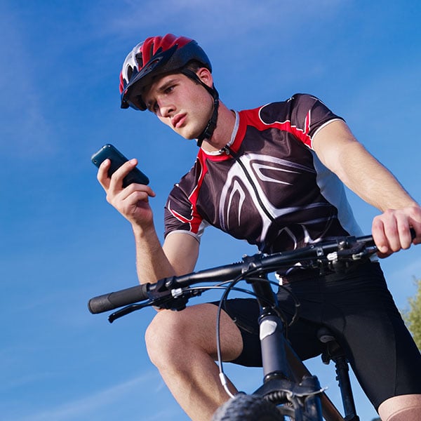 A cyclist that has stopped to look at their phone
